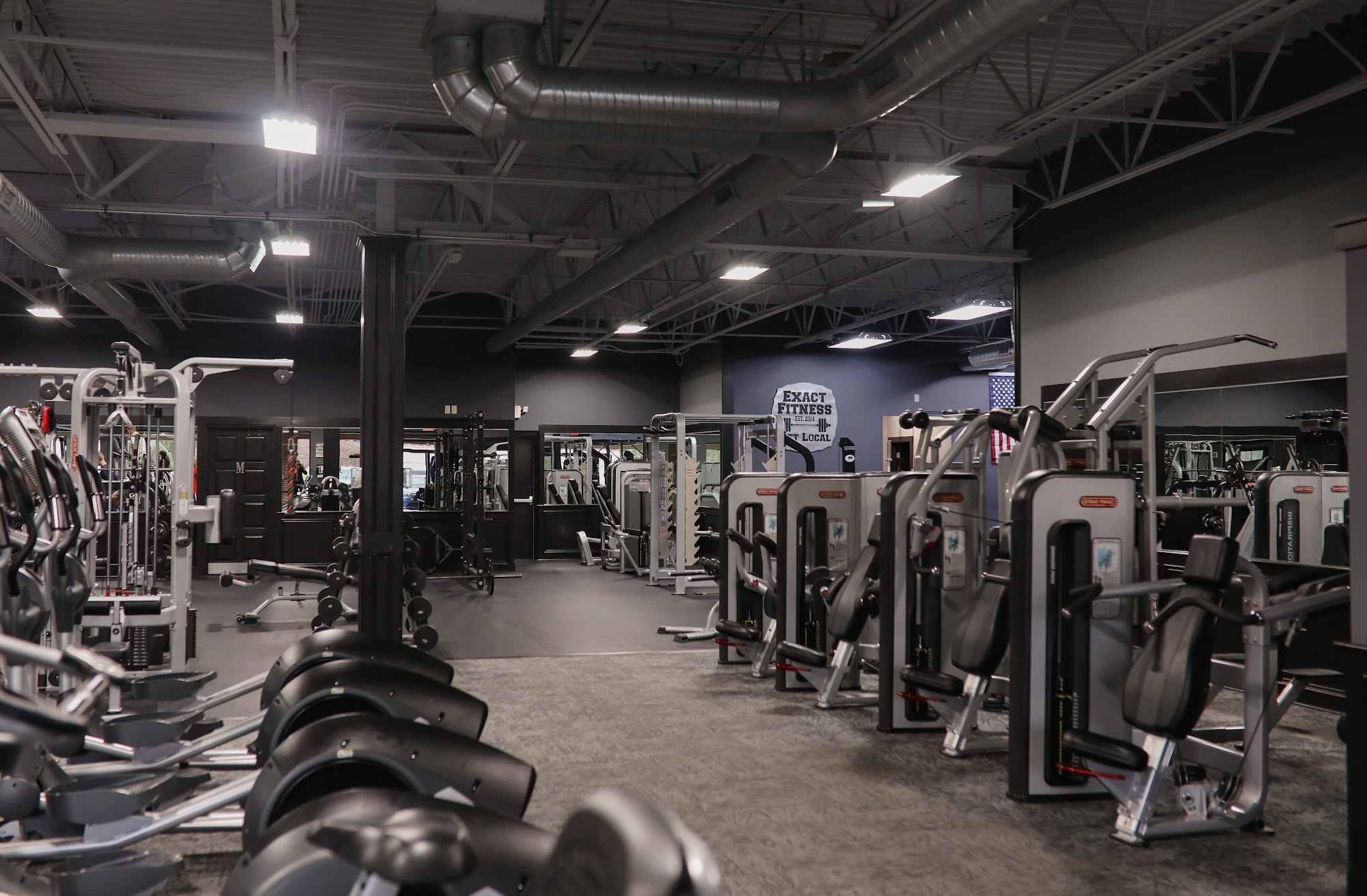 A wide view of the Exact Fitness gym floor and training equipment